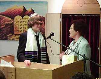 Polina Pelts presents the congregation's gift to Bar Mitzvah Julian